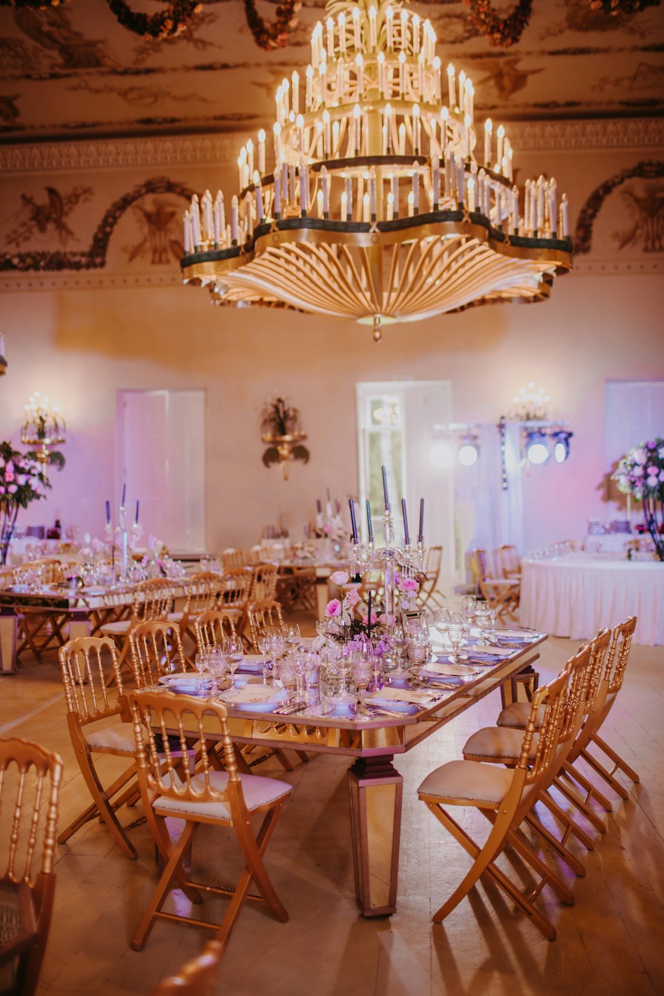 Wielka sala bankietowa przygotowana na formalną galę z eleganckimi stołami i krzesłami.
